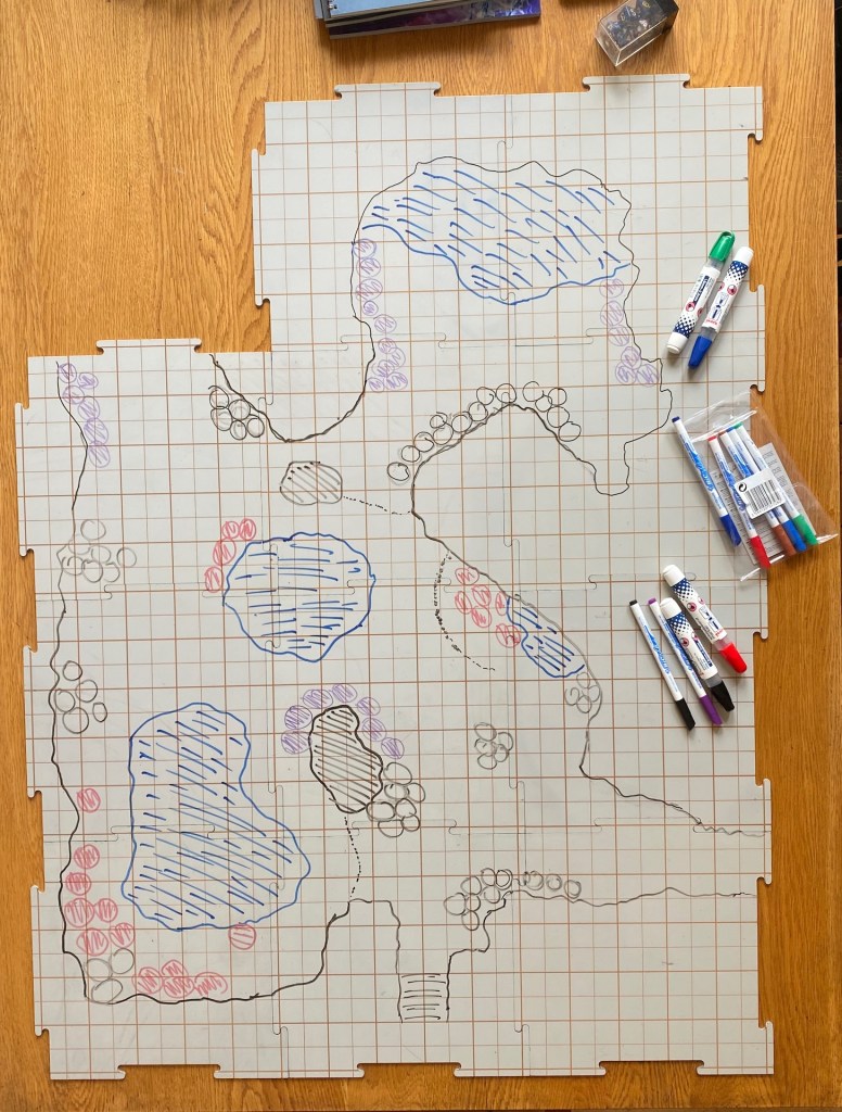 Map of a cave complex drawn on gridded tiles with whiteboard markers