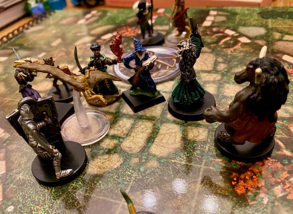 PC minis including minotaur, human wizard and summoned pterodactyl fighting a wight on a battle map
