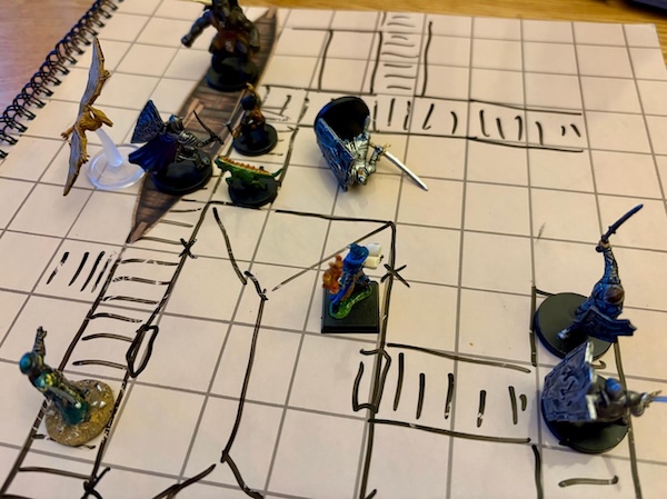 Hand drawn battle mat showing PC minis fighting Flaming Fist knights on a dockside