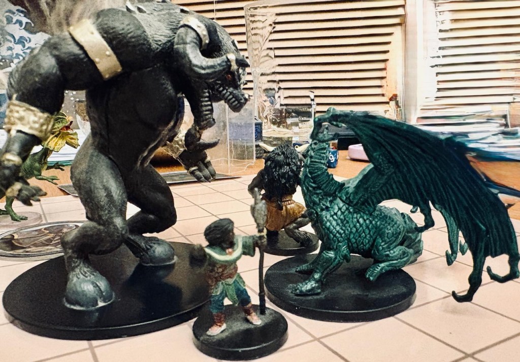 Giant ape mini towers over green wyvern and PC minis on battle grid