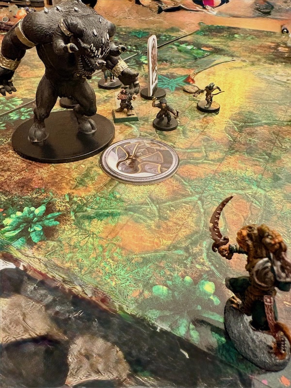 PCs miniatures including huge goristo demon as a stand in for giant ape battle weretiger minis on jungle battle mat.
