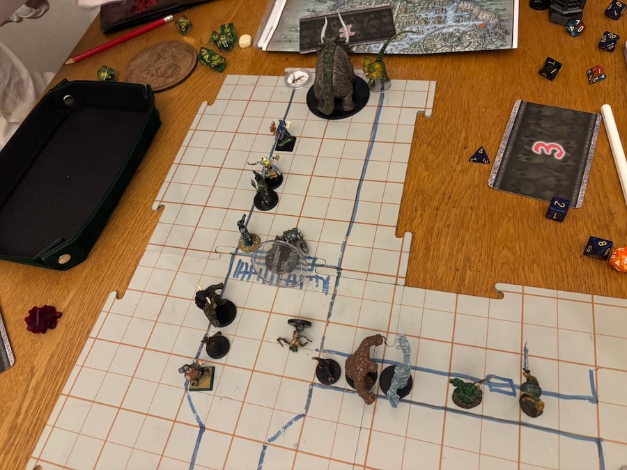 Handdrawn battle map on plastic tiles, triceratops mini, PCs minis, dice, initiative cards