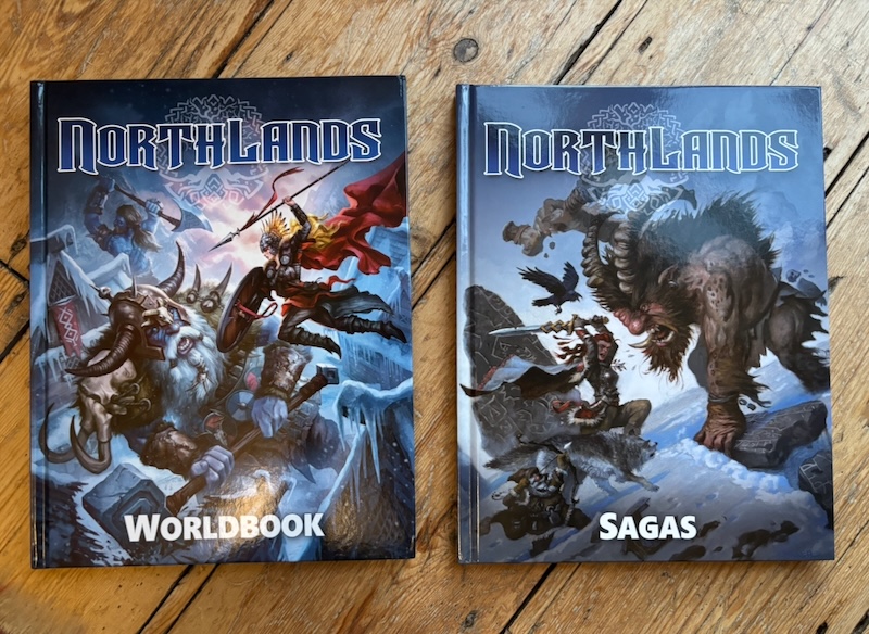 Northlands Worldbook and Northlands Sagas books on wooden surface