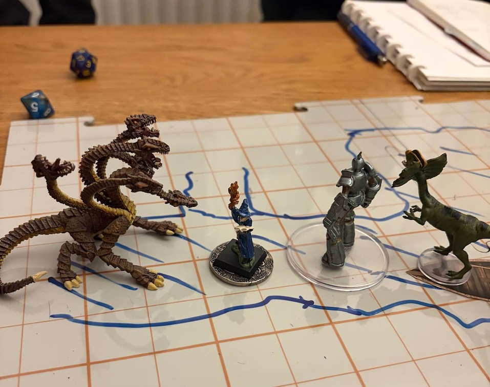 Handpainted hydra mini, wizard, shield guardian and dinosaur on hand drawn battle mat.