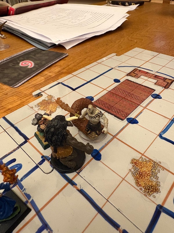 Dwarf, minotaur and wizard minis battle Ras Nsi on hand drawn battle map